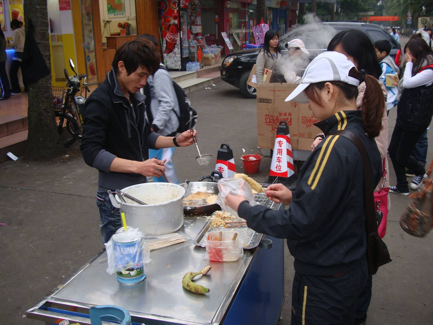 Picture:  This team of entrepreneurs have a deep frier set up on the street for plantain and bananas.  Tasty stuff.  Haikou on Hainan Island, China