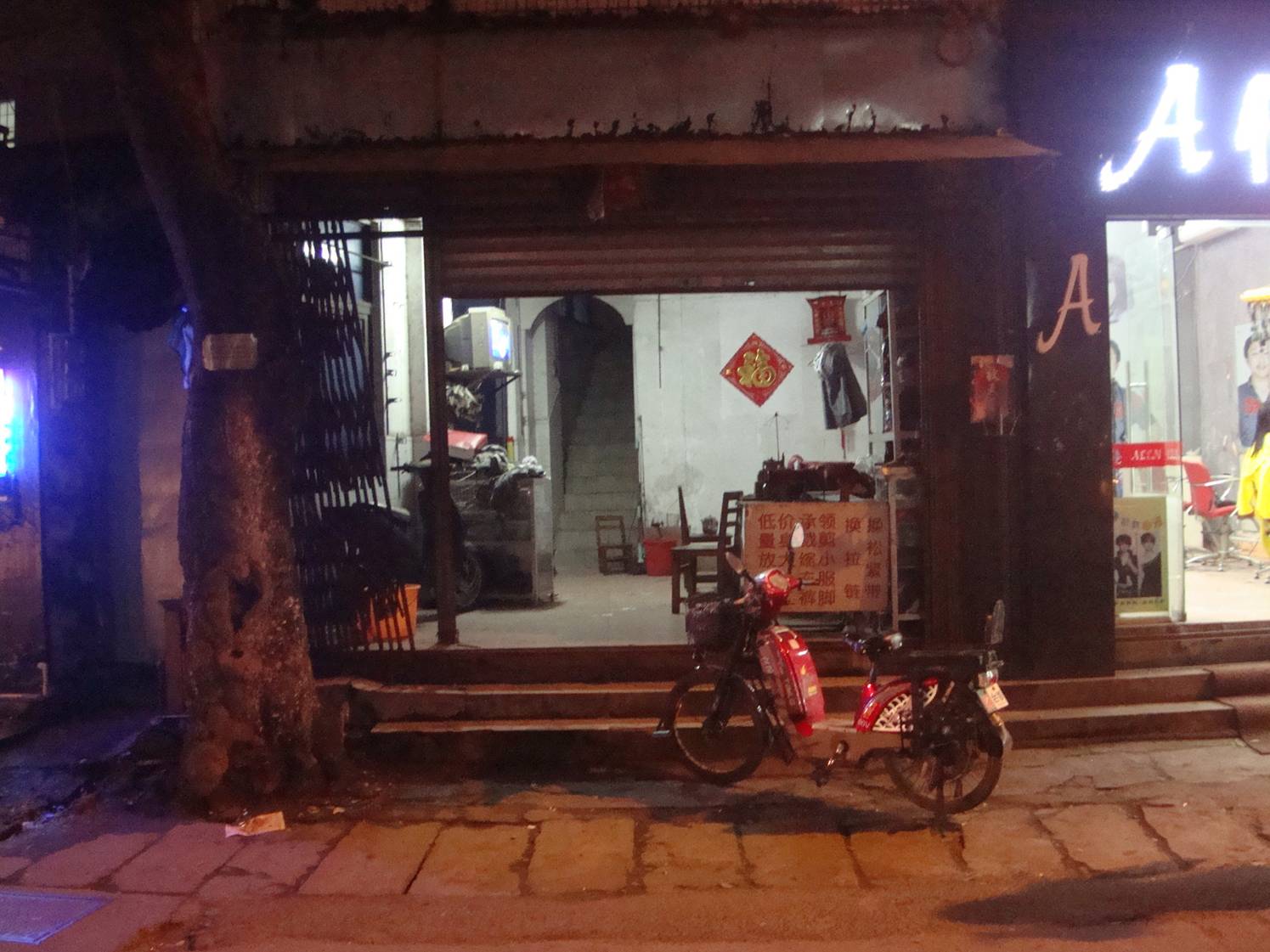 Picture:  A home on the streets of Haikou, Hainan Island, China.  It's tropical here, and the homes are often open.