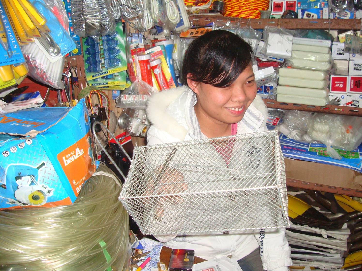 Picture:  The shop assistant holds a very effective live animal trap.  Haikou on Hainan Island, China