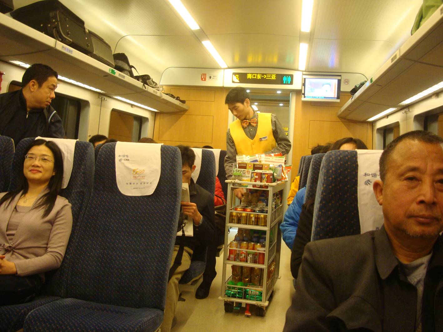 Picture:  The food cart on the Haikou-Sanya fast train.  Expensive food, but what price to be served by a guy in a bow tie.  Hainan Island, China