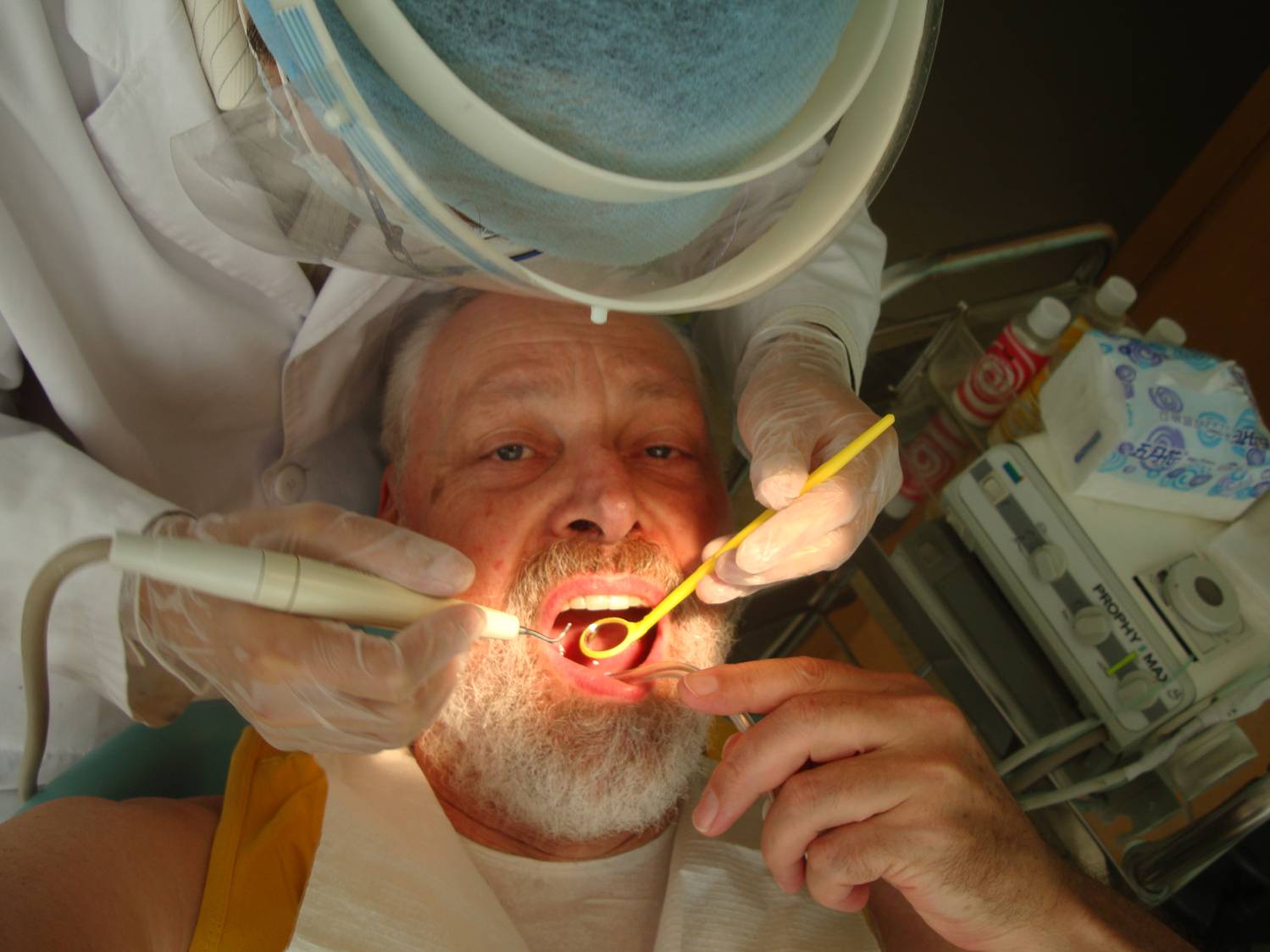 Note the gloves and mask. Comforting in an uncomfortable situation.  Dr. Zhou Wei An cleans my teeth,  Wuxi,  China