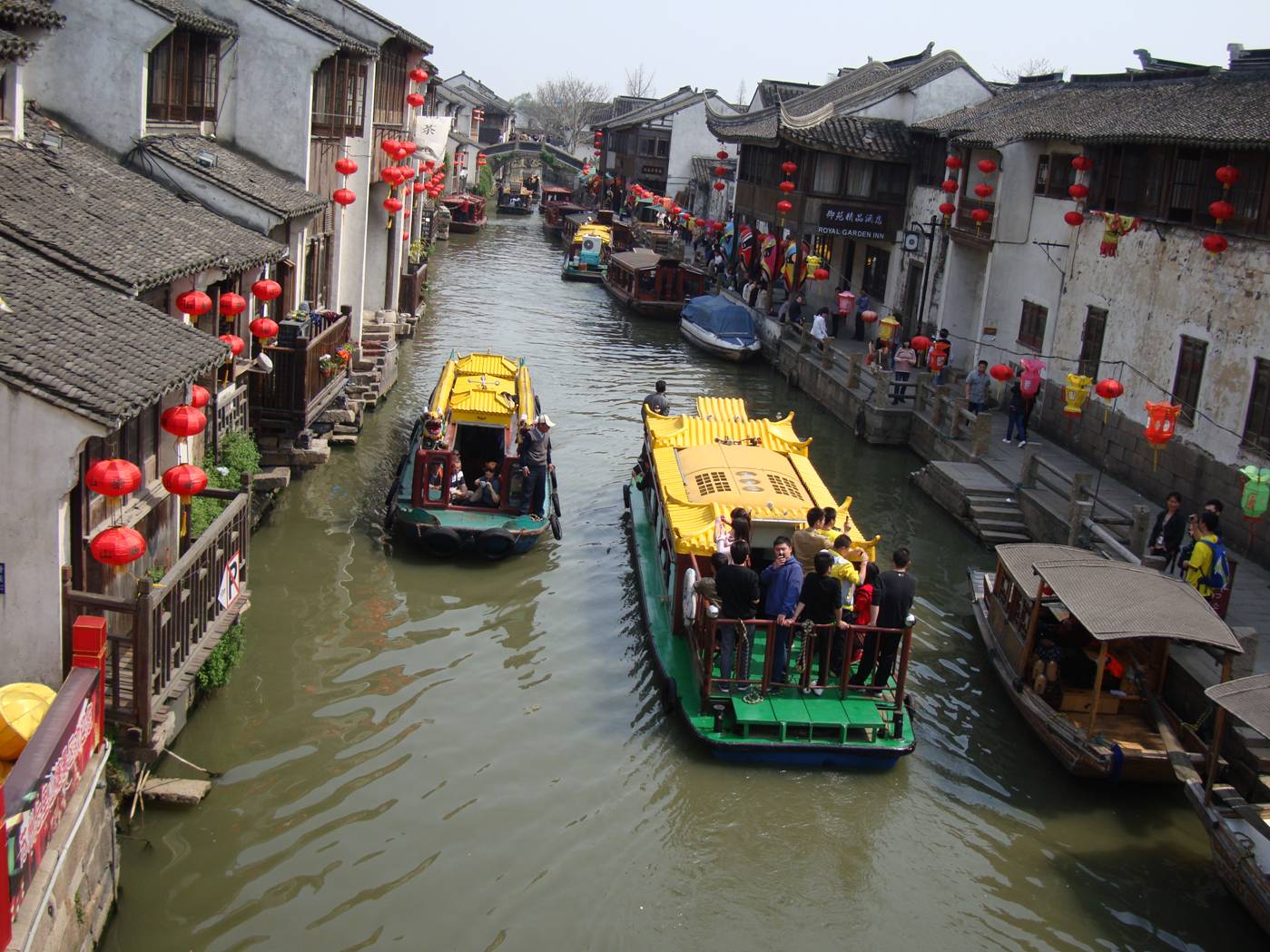 Picture:  Tour boats on the Suzhou canal as seen from a bridge.  It's a colourful city this time of year.  Suzhou, China