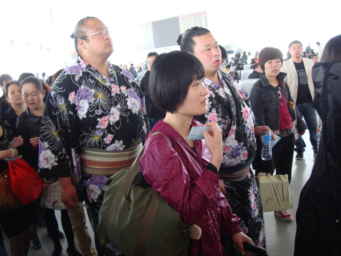 Picture:  Two Japanese sumo wrestlers in the lineup for the train in Wuxi train station.  Wuxi, China