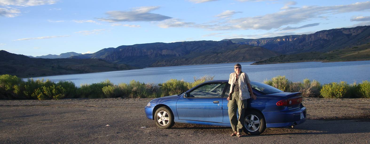 My wife, Ruth Anderson, and the little blue car someplace in Colorado, U.S.A.