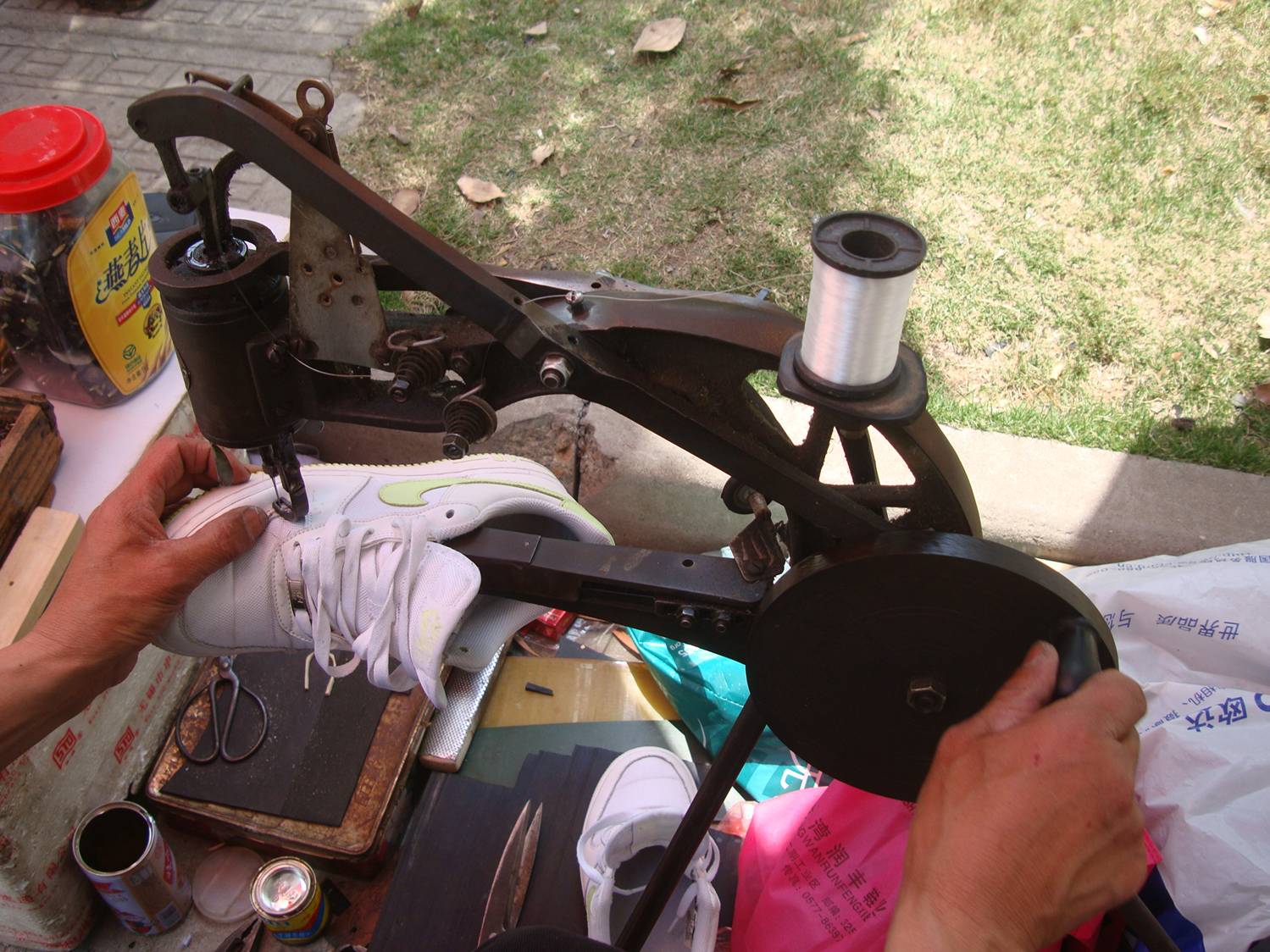 Picture:  The shoe repairman's hand cranked sewing machine, geared to punch through leather.  I know some sailors who would love to own a machine like this one.  Jiangnan University, Wuxi, China