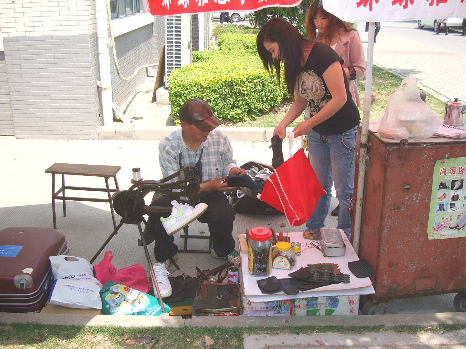 Picture:  A shoe repairman can set up his shop anywhere, and seems to be doing a lot of business.  Jiangnan University, Wuxi, China