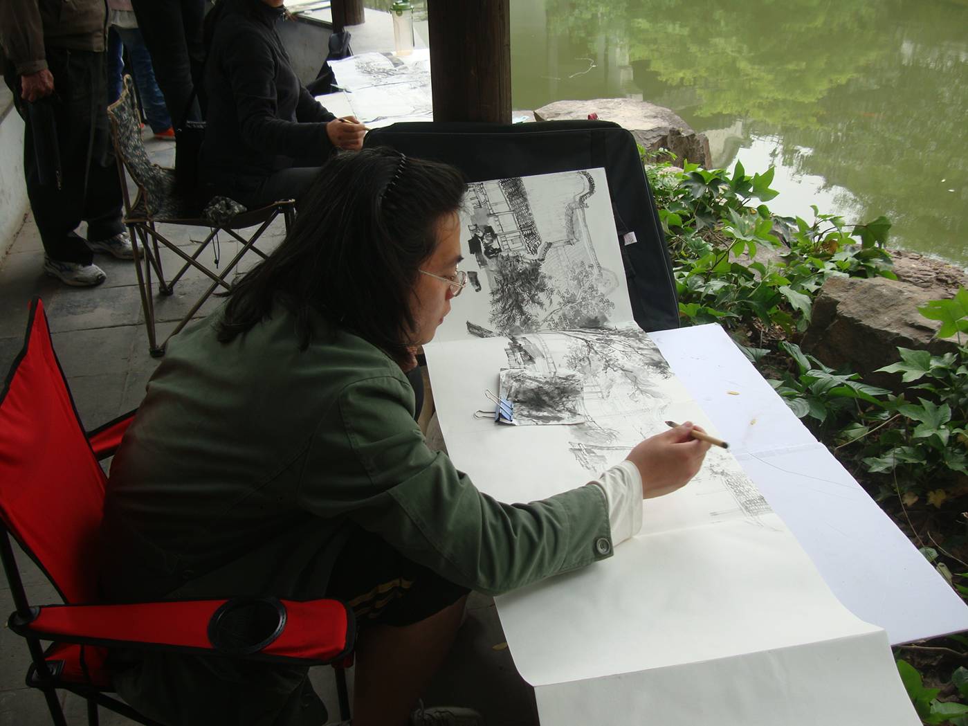 Picture:  Painters at work at the pond on the grounds of the museum outside Xi Hui Park, Wuxi, China