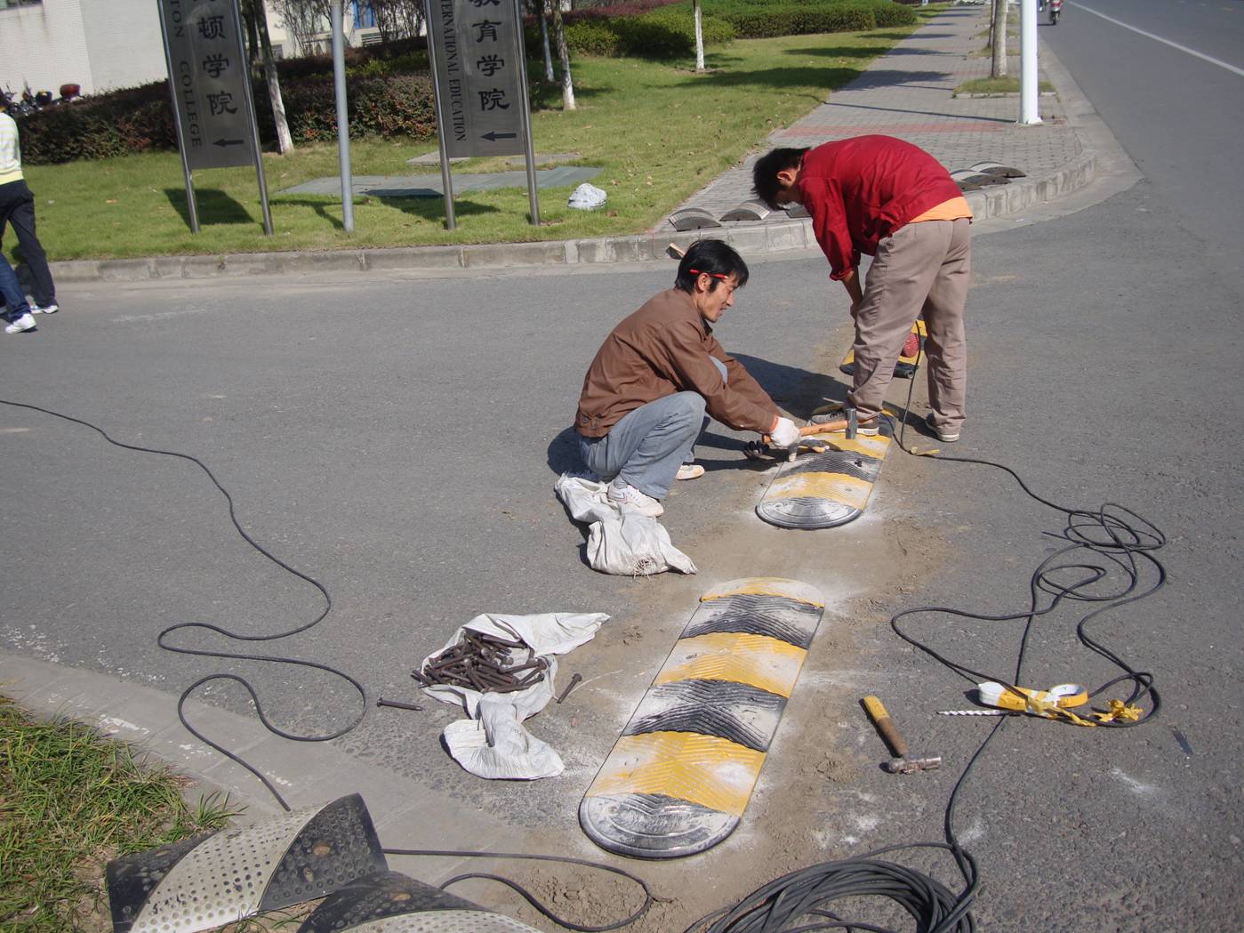 Workers replace the speed bumps with a more thoughtful design.  Jiangnan University, Wuxi, China